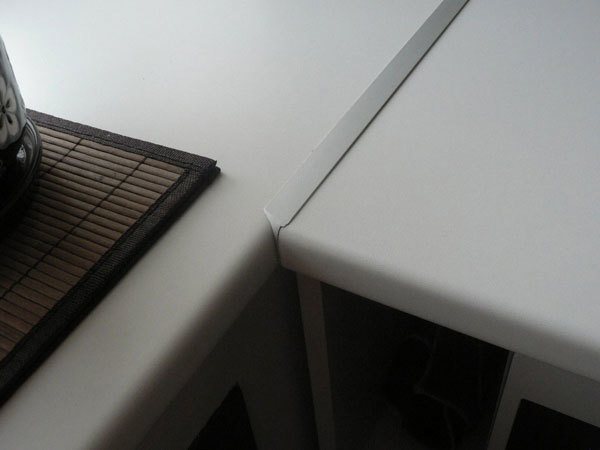 Mezera mezi dvěma polovinami desky stolu je zakryta kovovým pásem