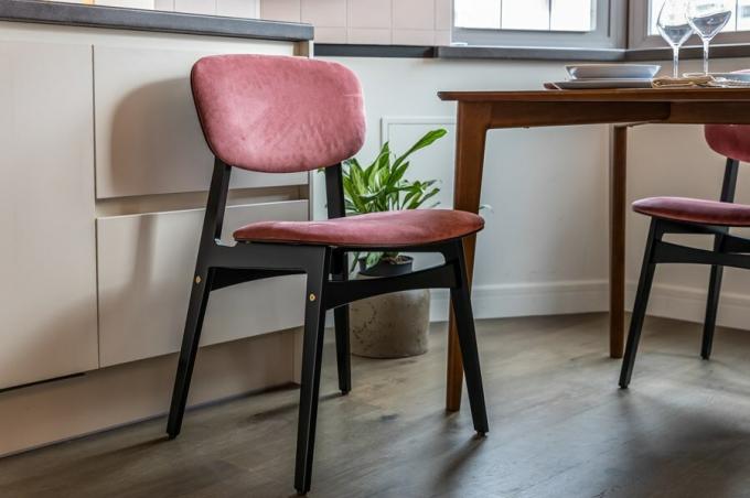 Vstříc jídelní stůl zvou čtyři židle vyrobené z březové překližky potažené odolným vůči vlhkosti skloviny, s opěradly a sedadly čalouněnými bohaté růžovém odstínu.