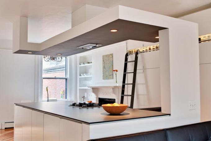 Přechody ze sádrokartonu, jako na fotografii, se často používají ke zlepšení zónování v kuchyních v kombinaci s jinými místnostmi