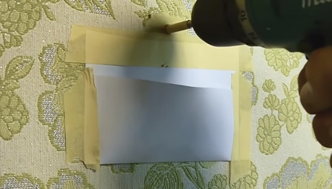 Kapsa z papíru a maskovací pásky bude chránit tapety od prachu, který vzniká při vrtání 
