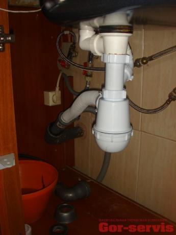 Správné uspořádání úhlu odtoku ze sifonu do kanalizační trubky, vyrobené pomocí vlnité hadice